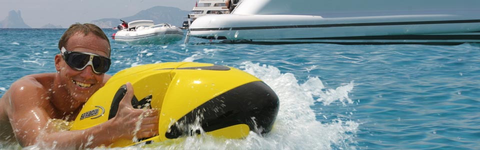 Man riding the seabob with thumbs up and a motor yacht in the background.